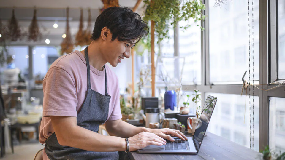 Man smiling looking at computer in store.